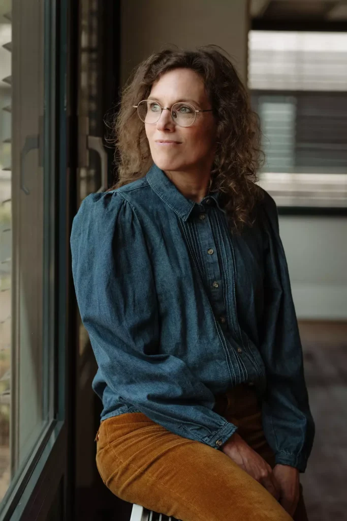 Portret van Suzanne, redacteur en tekstschrijver, zittend bij het raam en dromerig uitkijkend