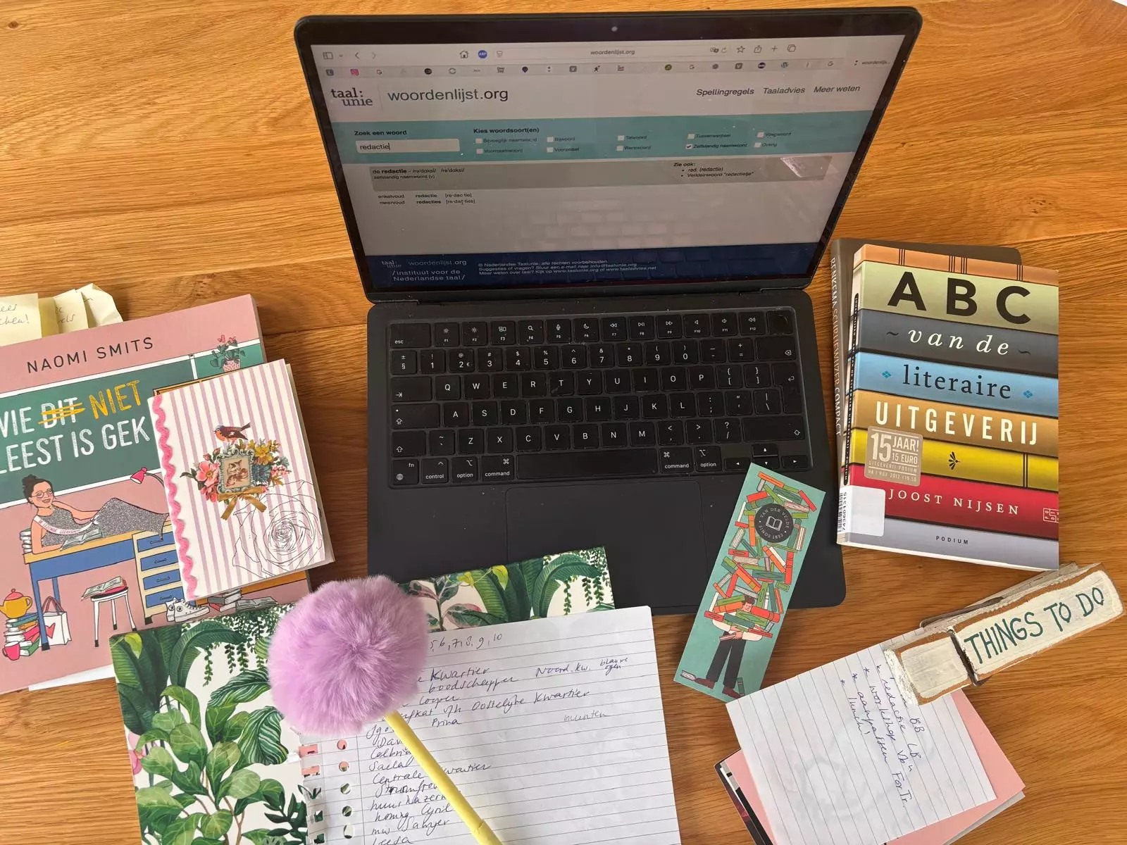 Bureau met laptop, boeken en visitekaartje van Bergman Teksten – visuele weergave van redactie- en schrijfwerk