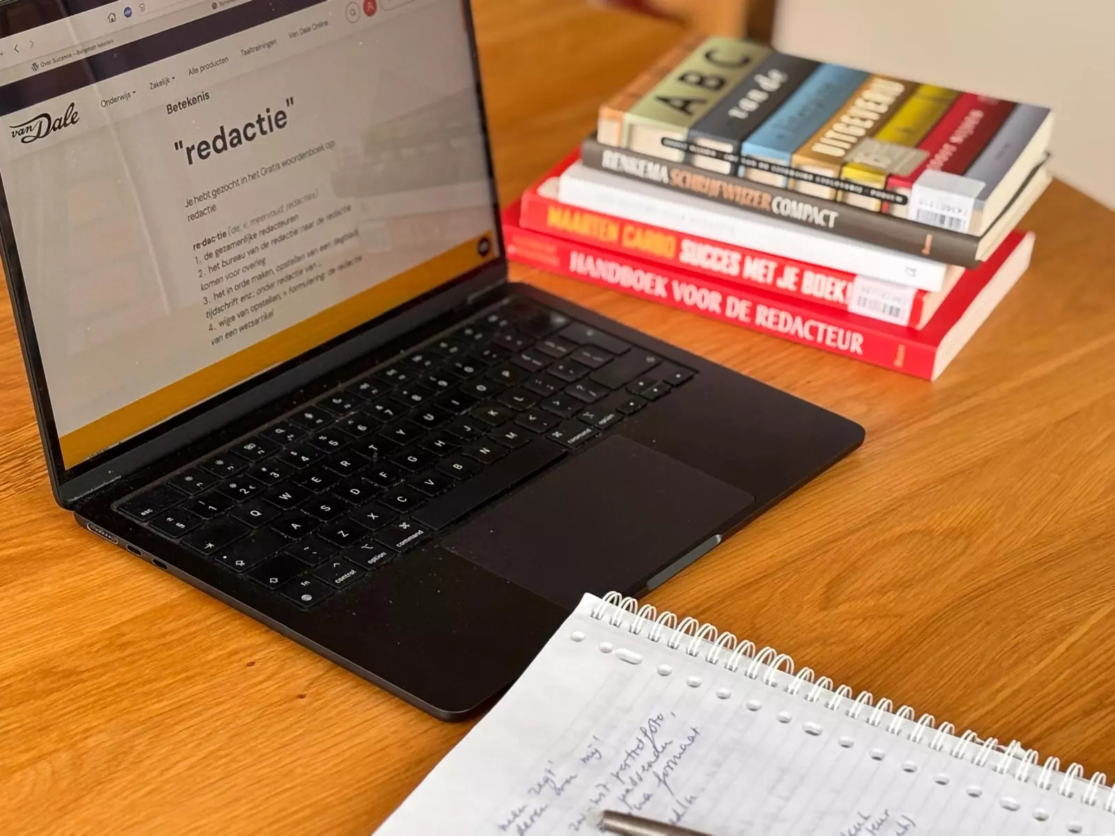 Boekredactie – laptop met opengeslagen boek